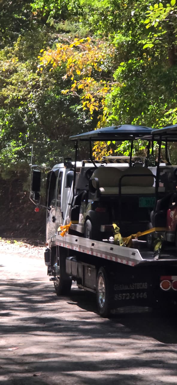 Grúas Guanacastecas flatbed transporting golf carts